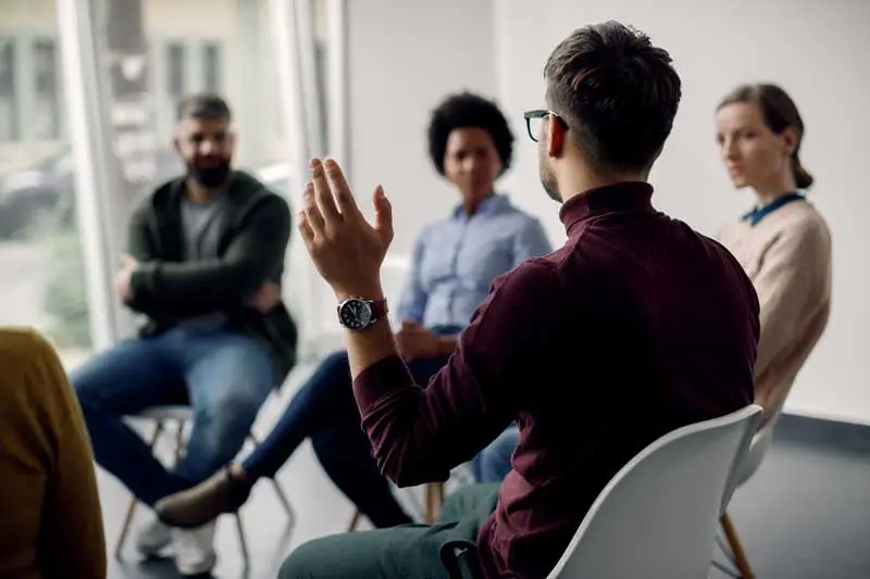 man raising hand in focus group