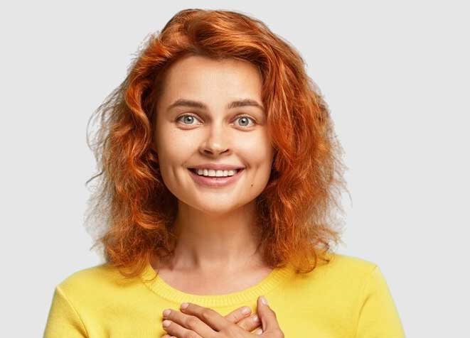 woman holding hands over heart